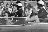 President John F. Kennedy waves from his car in a motorcade approximately one minute before he was shot, Nov. 22, 1963, in Dallas. 