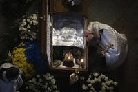 Priest pays his respects at coffin of Ukrainian poet Maksym Kryvtsov