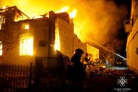 Firefighters work on the site of a burning building.