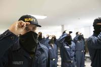 New Navy sailors don their Navy ball caps during a capping ceremony