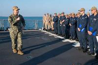 Vice Adm. Brad Cooper presents a combat medal to a USS Carney sailor