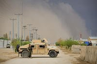 An Afghan National Army (ANA) soldier, assigned to the 215th Corps, stands next to an ANA Humvee while guarding the Operational Coordination Center-Regional (OCC-R) during the Afghan presidential elections as a sandstorm approaches aboard Camp Shorabak, Helmand province, Afghanistan, April 5, 2014. (Lance Cpl. Darien J. Bjorndal/U.S. Marine Corps photo)