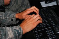 A service member works on a computer at Osan Air Base, Republic of Korea.