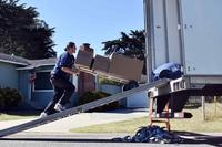 Movers load a service member’s household goods into a moving truck