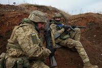 Ukrainian servicemen take position in a trench during a military exercise