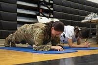 U.S. Air Force Maj. Meredith Studer, 36th Operational Medical Readiness Squadron physical therapist, competes in a plank competition with a student during the Tiyan High School Health Fair in Barrigada, Guam