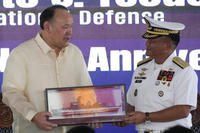 Philippine Defense Secretary Gilberto Teodoro, left, receives a memento
