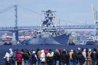 People gather in Gloucester City, N.J., to view the USS New Jersey moved down the Delaware River