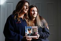 Pamela Yarosz and her daughter Capri are shown with a photo of New York firefighter Christopher Michael Mozzillo