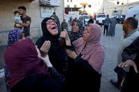 Palestinians mourn for relatives killed in the Israeli bombardment of the Gaza Strip at a hospital morgue