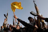 Houthi supporters raise a Hezbollah flag in Sanaa, Yemen