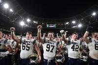 Navy football players salute their supporters