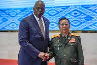 Laos' Defence Minister Chansamone Chanyalath, right, welcomes US Defence Secretary Lloyd Austin