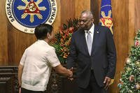 U.S. Defense Secretary Lloyd Austin, right, shakes hands with Philippine President Ferdinand Marcos Jr.