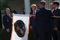 The flag of the U.S. Space Command is unfurled at the White House