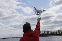 Drone operator helps to retrieve a drone over Hart Island in New York