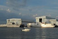 A Littoral Combat Ship (left) and an Expeditionary Fast Transport sit docked at Austal USA's manufacturing facility