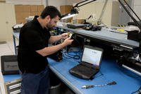 Adam Lee inspects components of the Common Aircraft Portable Reprogramming Equipment, a system organically engineered by the 309th Software Engineering Group at Hill Air Force Base, Utah.