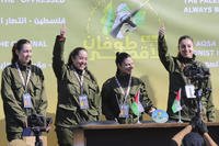 Israeli female soldier hostages wave to the crowd.