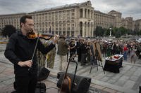 A musician plays the violin during the funeral ceremony for volunteer servicewoman, well-known stylist Shura Riazantseva