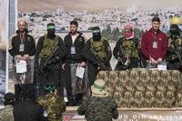 Israeli hostages are escorted by Hamas and Islamic Jihad fighters.