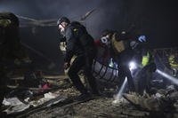 Police officers carry the body of a person killed by a Russian drone strike.