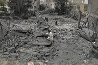 A Yemeni walks over the debris of a destroyed building following U.S. airstrikes