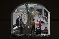 Palestinians inspect the site hit by an Israeli strike in Deir al-Balah, Gaza Strip