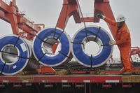 A worker loads rolls of steel plate at a steel market in Hangzhou in east China's Zhejiang province.