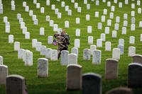 Flags are placed at the headstones of service members buried at Arlington National Cemetery.