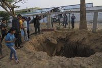 Palestinians inspect the site of an Israeli army airstrike on the European hospital in Khan Younis, Gaza Strip