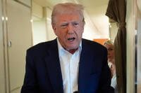 President Donald Trump talks with reporters on Air Force One as he heads back to Washington