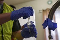 A Navy contractor tests a drinking water sample collected at a military housing residence in Honolulu.