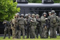 Law enforcement officers stage less than a mile from a shooting in Brooklyn Park, Minnesota.