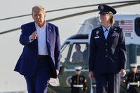 President Donald Trump, left, escorted by Air Force Col. Angela F. Ochoa, Commander, 89th Airlift Wing