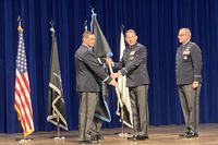 New Space Force STARCOM commander Maj. Gen. James Smith takes a ceremonial guidon from Space Force Gen. Chance Saltzman, chief of Space Operations, as previous STARCOM commander Maj. Gen. Timothy Sejba looks on during an event at Patrick Space Force Base.
