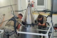 Senior Airman Jacob Deas and Airman 1st Class Jonathan Marrs secure a titanium shroud