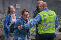 Women react outside a destroyed apartment building after a Russian missile attack in Kyiv, Ukraine