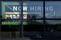 A hiring sign is displayed at a grocery store