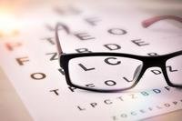 Glasses and an a screening card for an eye exam.