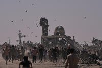 Palestinians collect leaflets dropped by an Israeli drone, warning people to stay away from the so-called yellow line in Khan Younis, in the southern Gaza Strip.