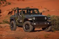 A front three-quarter shot of an army green 2024 Jeep Wrangler posing in a desert