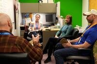 Four people in civilian clothes in an office.