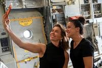 Two military spouses take a selfie together inside an aircraft.
