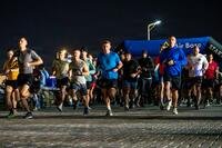Airmen run toward the camera in the dark.