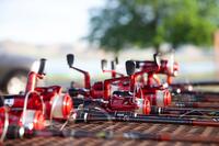 A row of red fishing reels and rods.