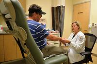 Award winning nurse practitioner Demerise &quot;Dee&quot; Minor checks for tenderness in Gene Abston's hand after he sustained a fracture.. (Dorn VA photo)