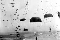 Parachutes open overhead as waves of paratroops land in Holland during operations by the 1st Allied Airborne Army. (Photo: National Archives)