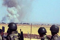 Turkish soldiers stand as smoke billows from the Syrian town of Ayn al-Arab or Kobani following the attacks by IS militants as seen from the Turkish side of the border in Suruc, Turkey, Thursday, June 25, 2015. (AP Photo)