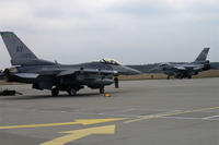 A Polish F-16 Fighting Falcon taxis past a 555th Fighter Squadron F-16 before a training mission, March 18, 2014, at Lask Air Base, Poland.